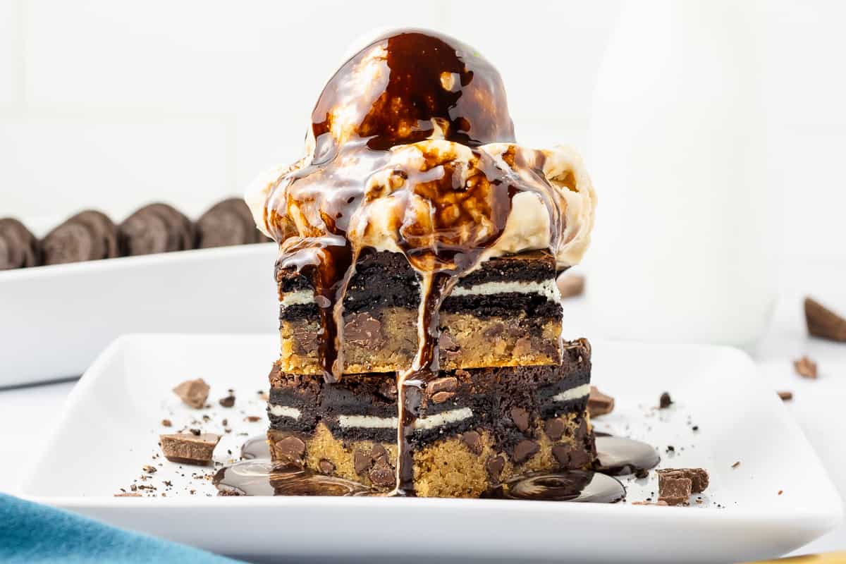 Ice cream on top of a stack of brownies.