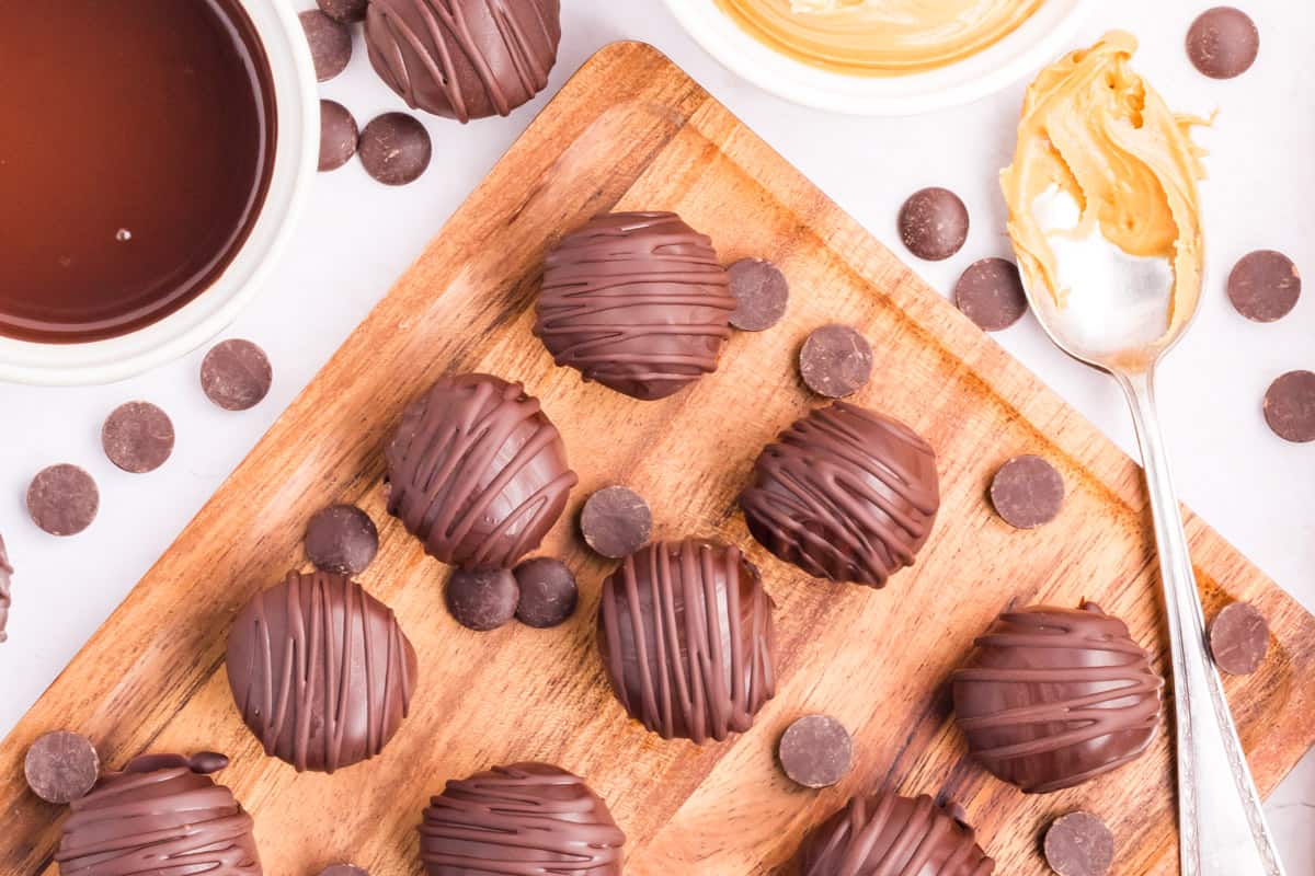 A bunch of chocolate truffles on a cutting board.