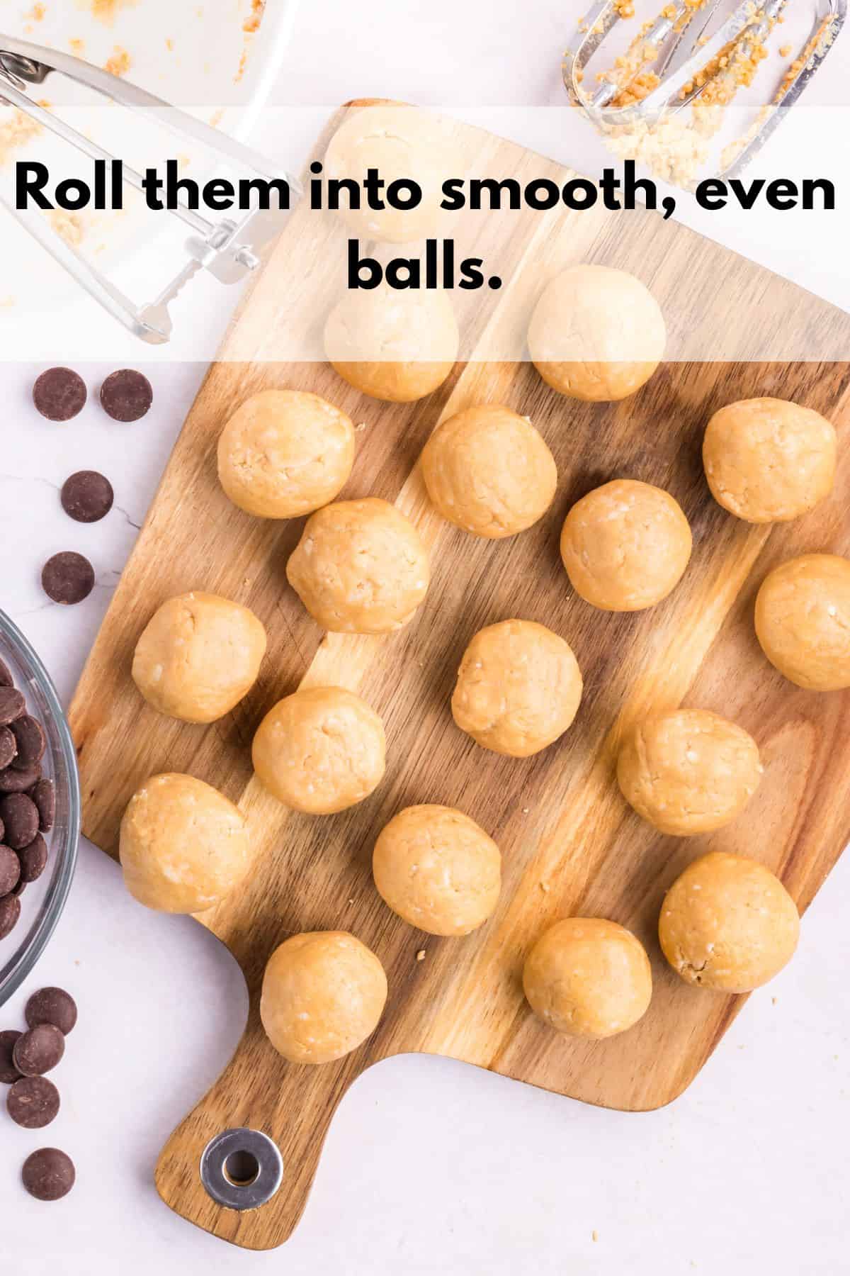 Some small round balls of truffle filling on a cutting board.