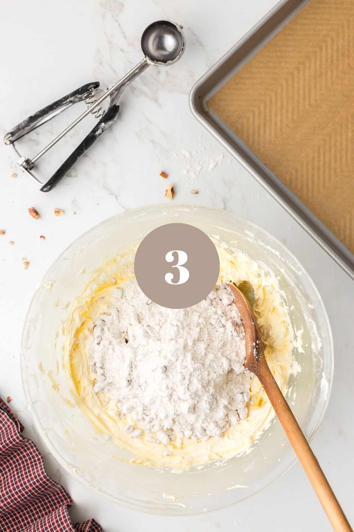 Adding flour to some other ingredients in a mixing bowl.