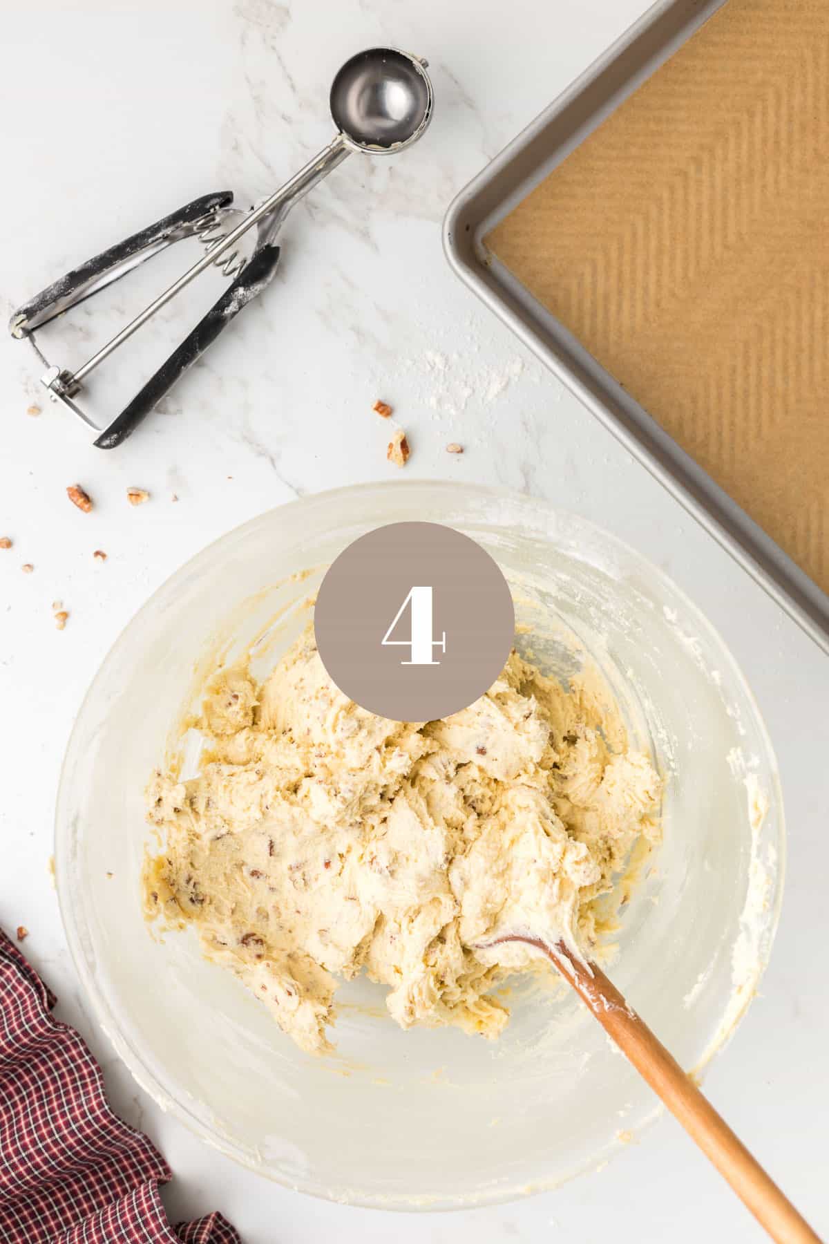 A wooden spoon stirring some cookie dough in a mixing bowl.