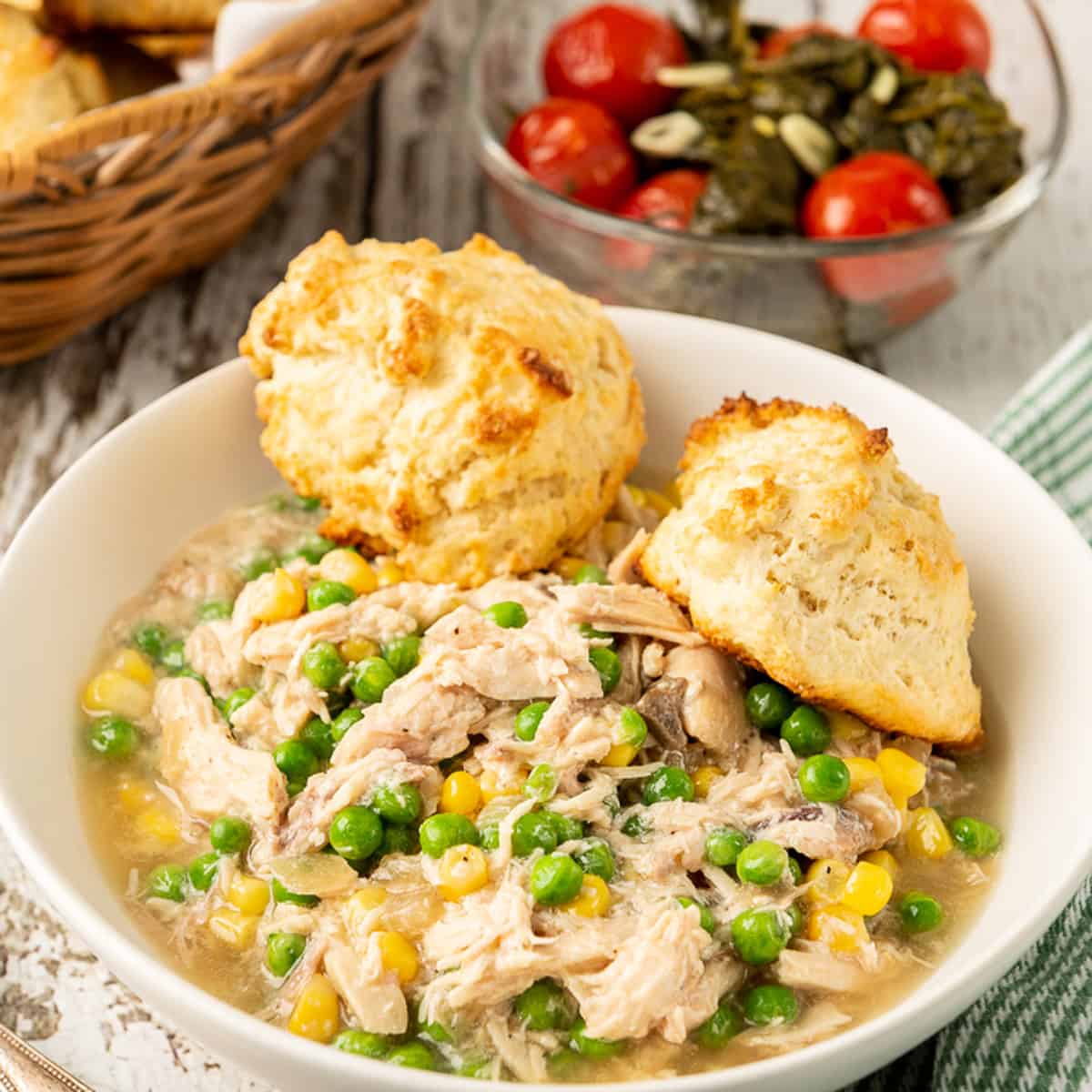 A bowl of chicken and biscuits.
