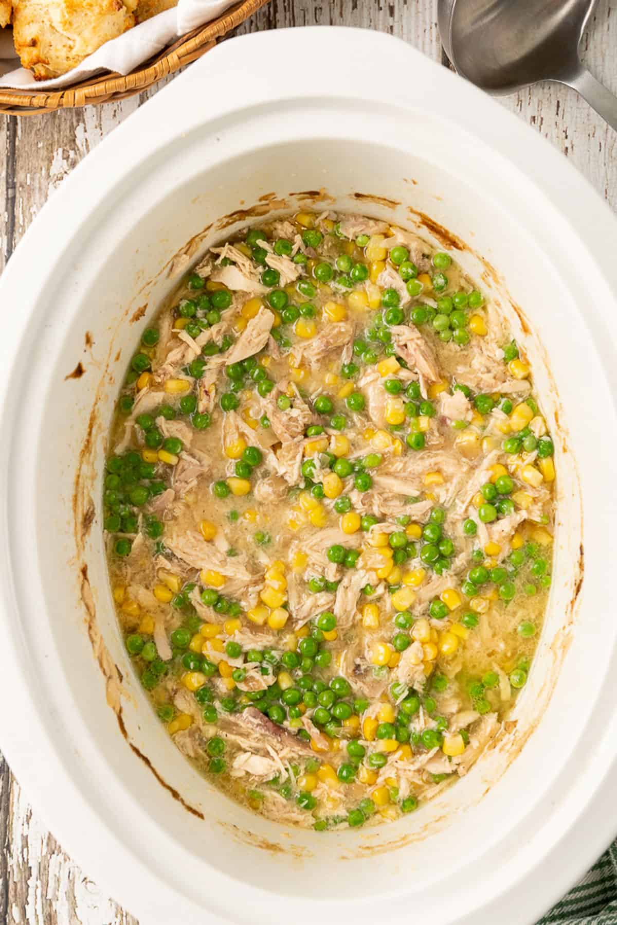 A slow Crock Pot of chicken and peas and corn.