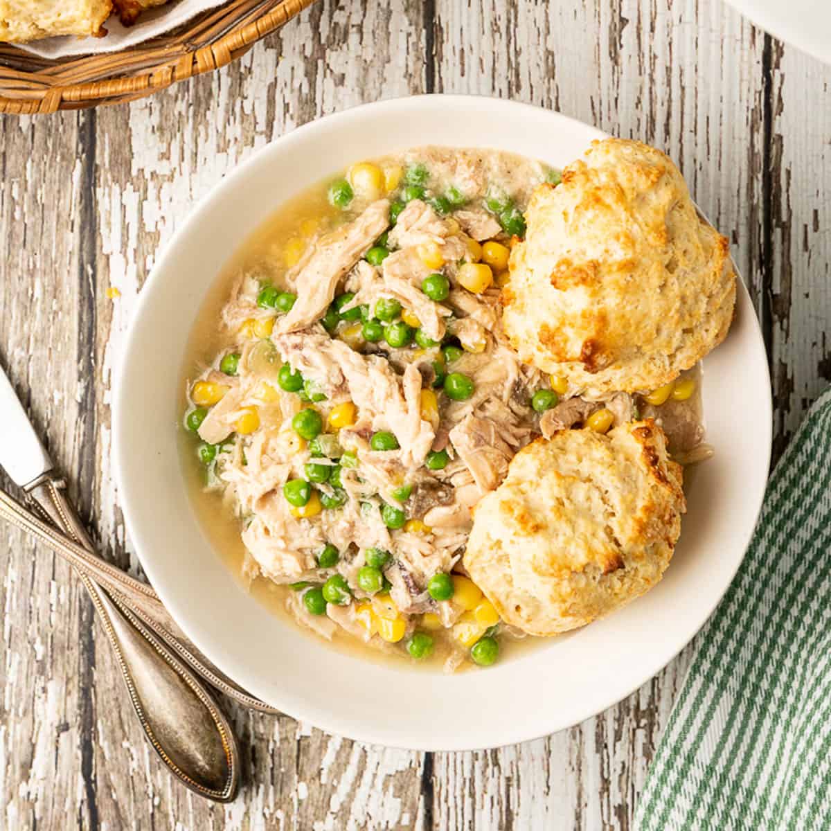 A bowl of chicken and biscuits.