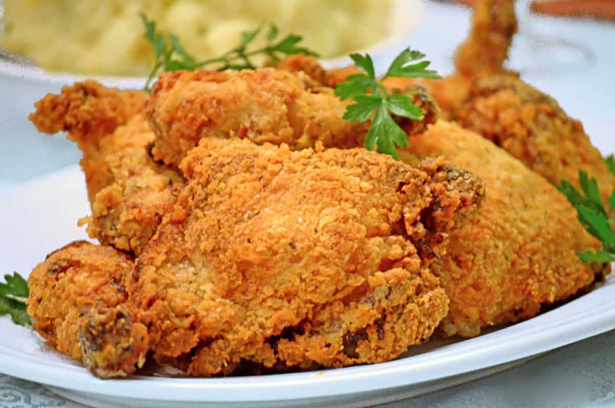 A plate of fried chicken with some parsley garnishes.