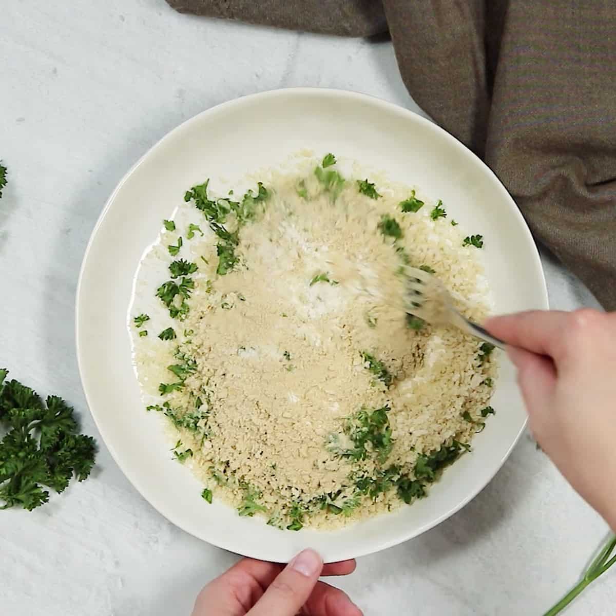 Mixing up some flour and breadcrumbs and chopped parsley.