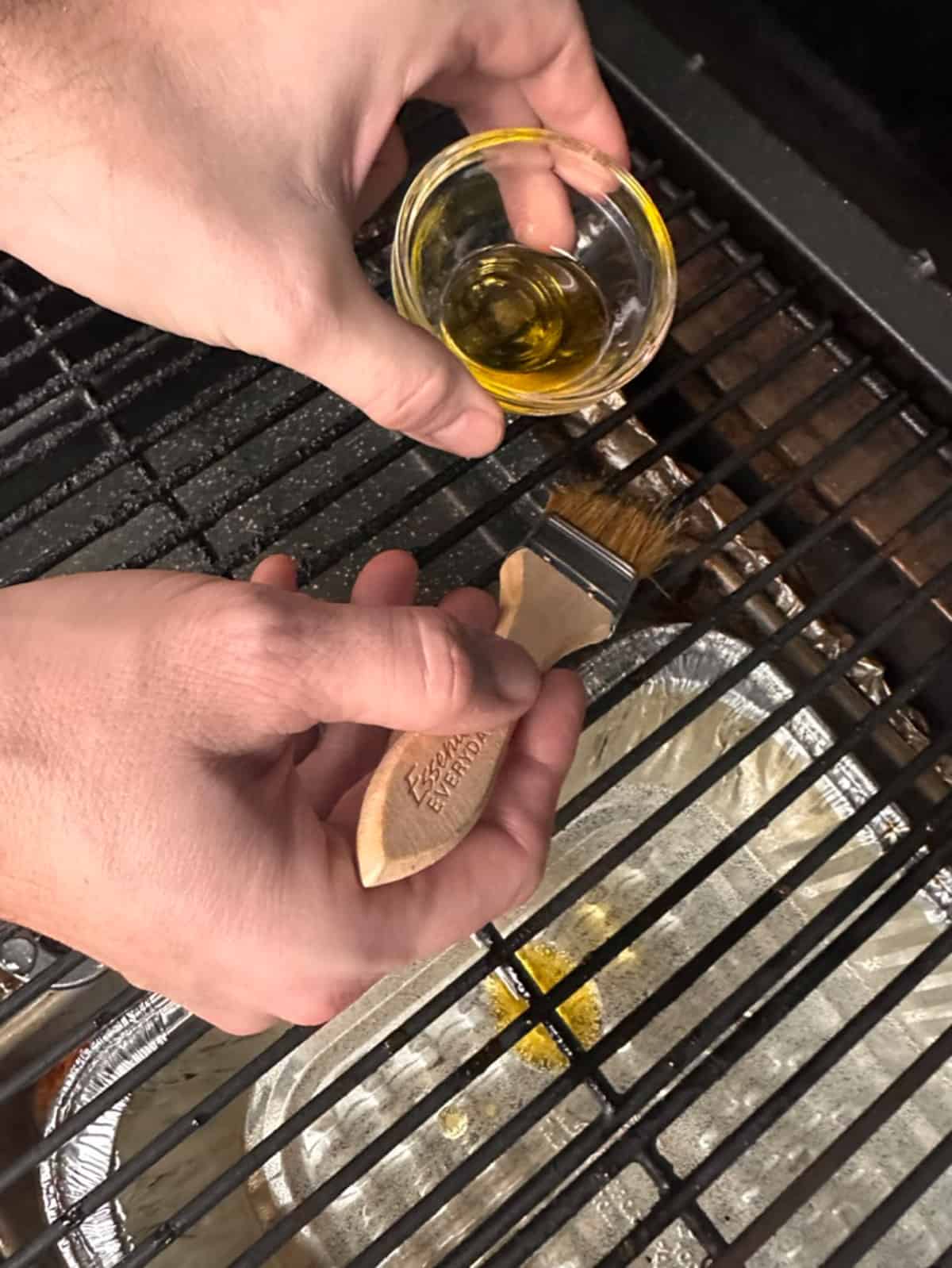 Brushing oil on a grill grate.