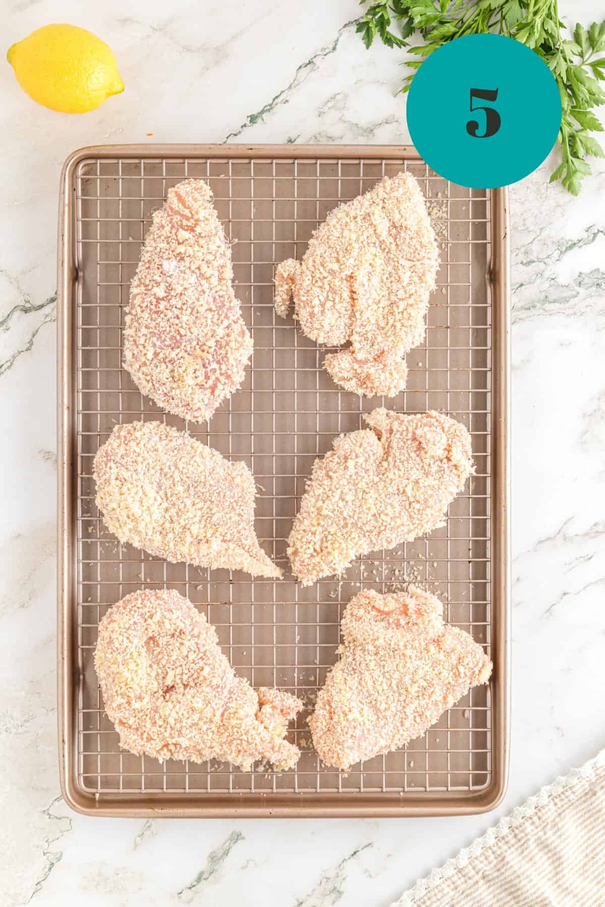 A bunch of uncooked chicken on a baking rack.