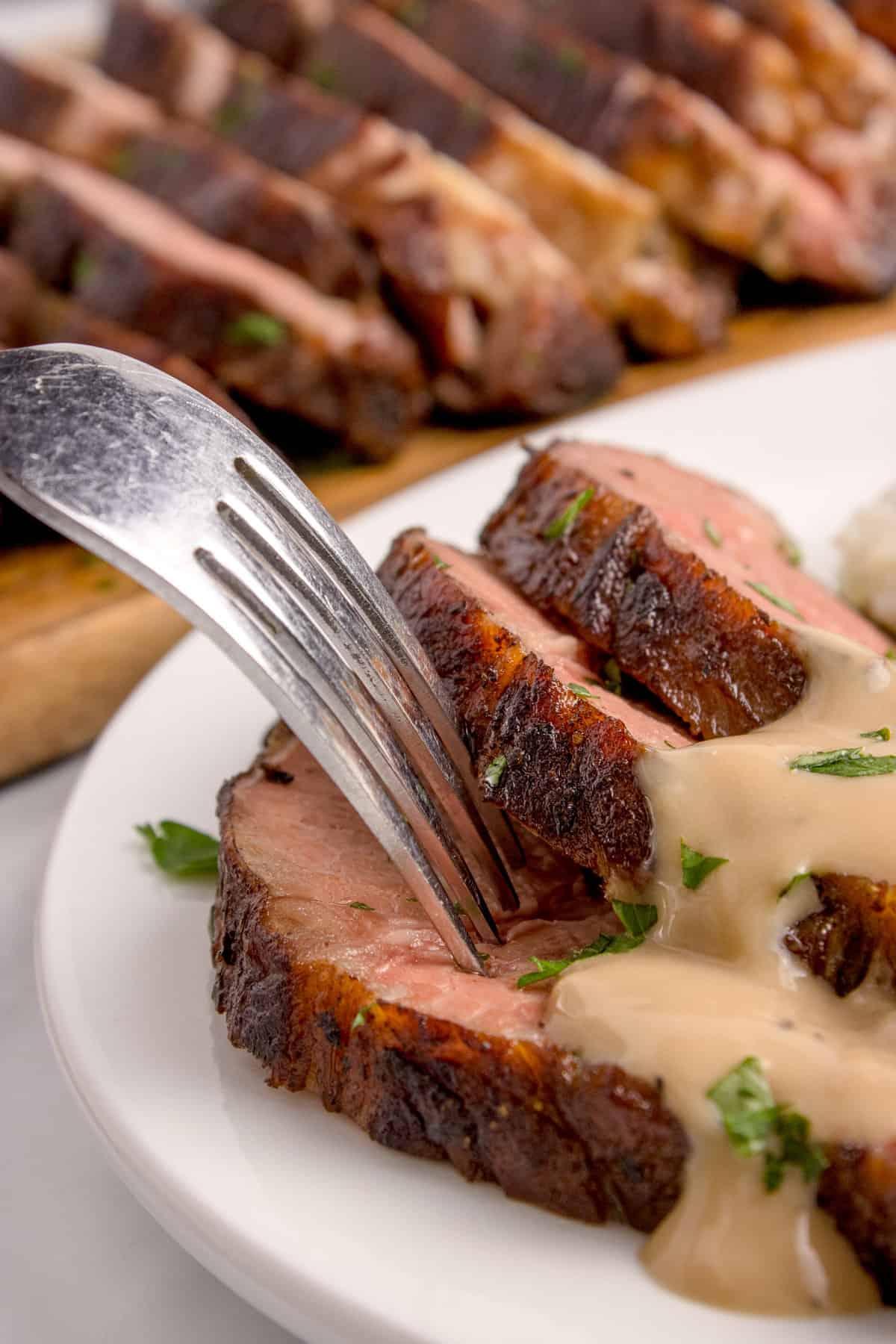 A plate of beef with gravy.