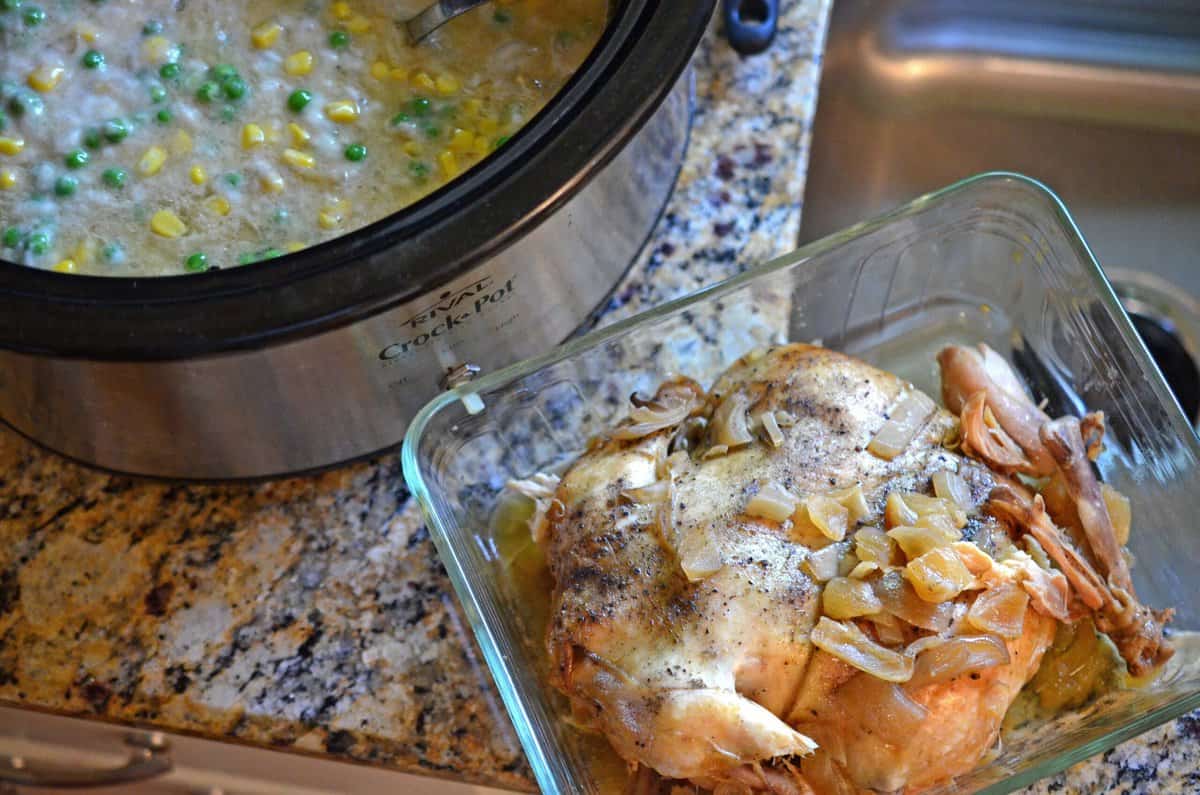 A whole cooked chicken, next to a slow cooker.