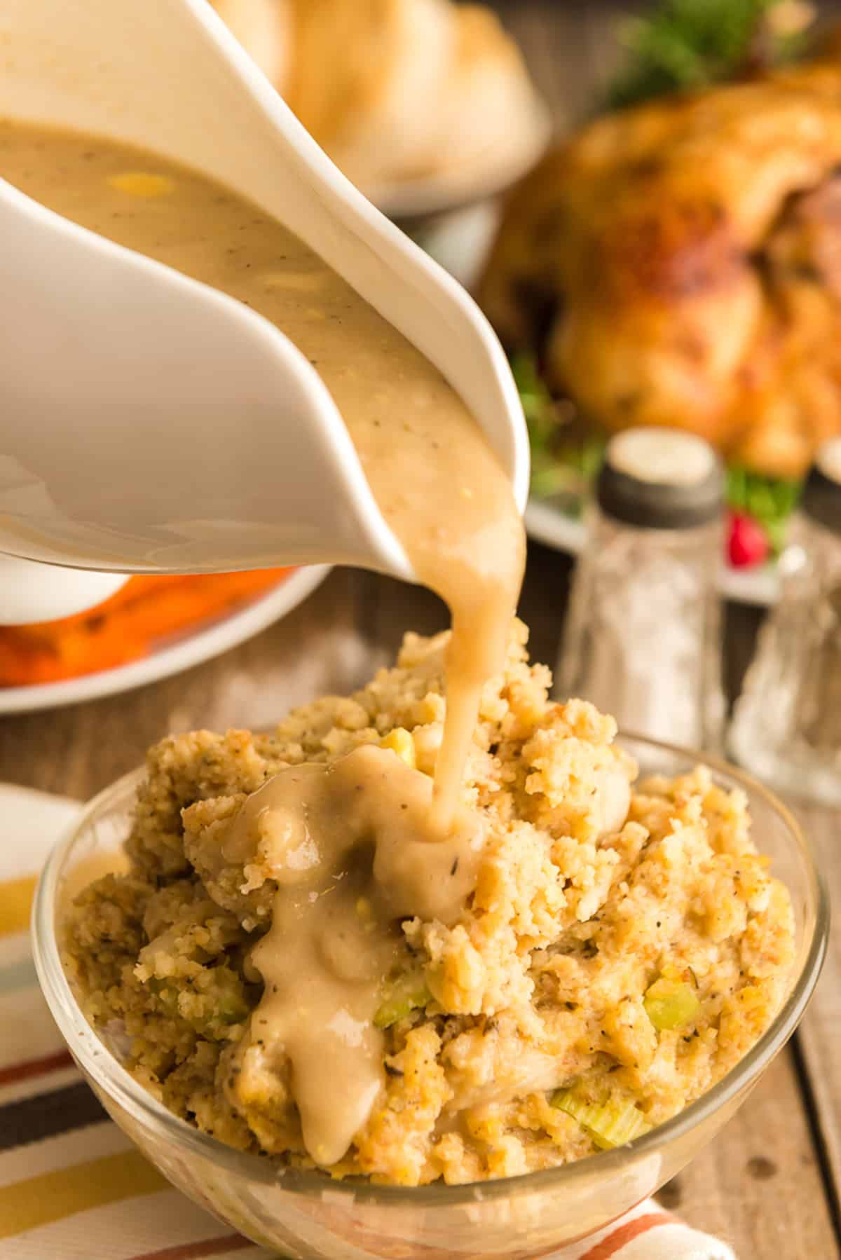 Pouring gravy over stuffing.