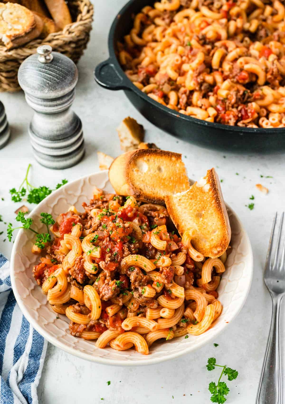 A plate of old fashioned goulash with some crusty bread.