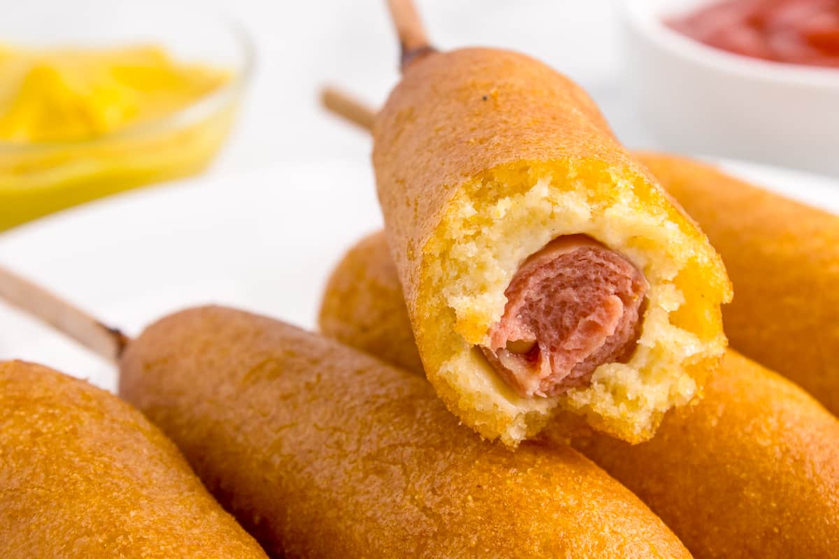 A corn dog with a bite taken out of it.
