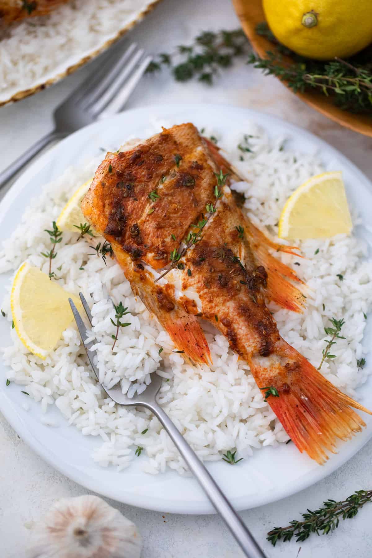 A baked fish on a bed of white rice.