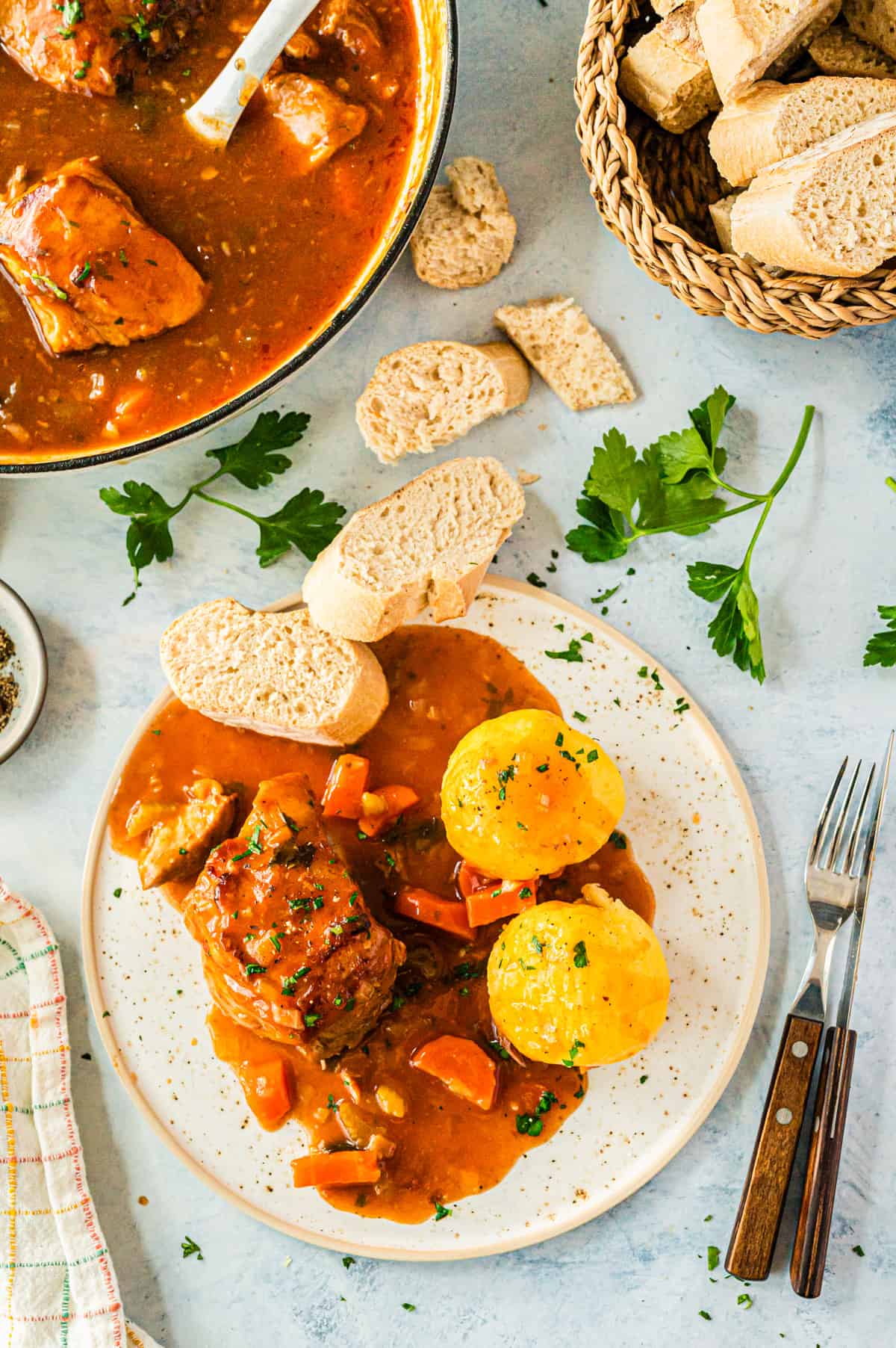 Overhead view of a plate of meat, bread, and dumplings.