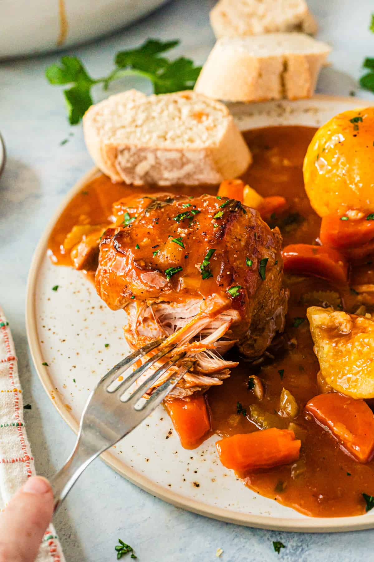 A plate of meat with a fork digging into it.