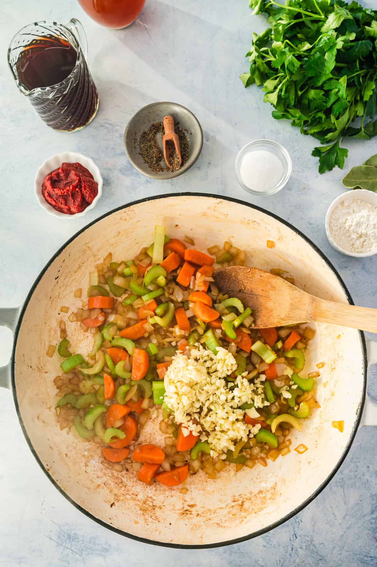 Stirring an uncooked mirepoix in a pot.