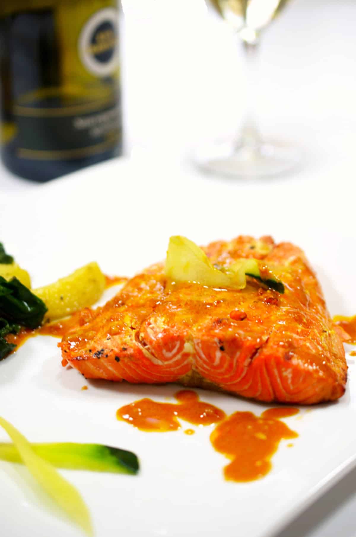 A plate of salmon with orange sauce on it.