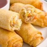 A plate of egg rolls and sauce.