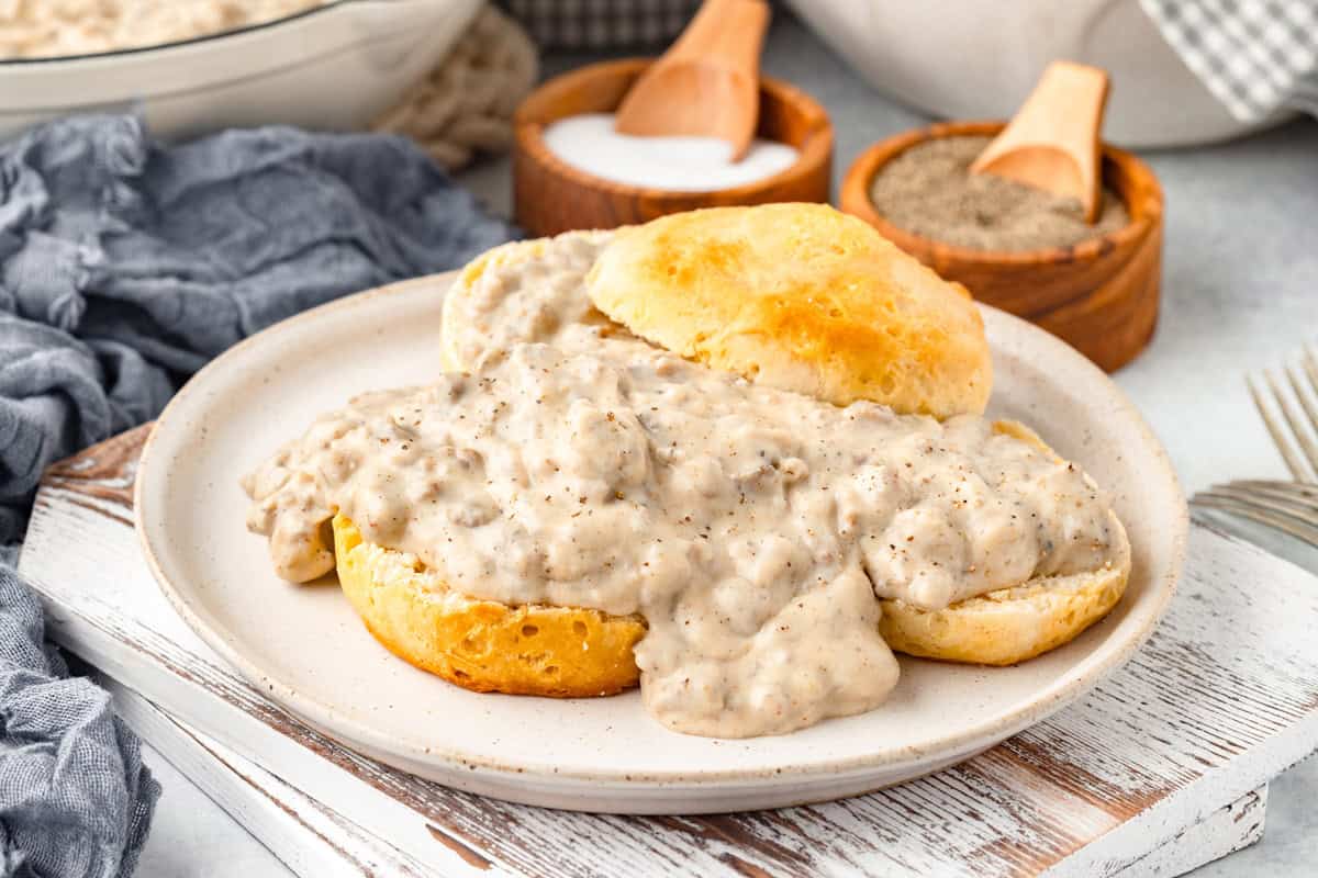 A plate of biscuits covered in sausage gravy.