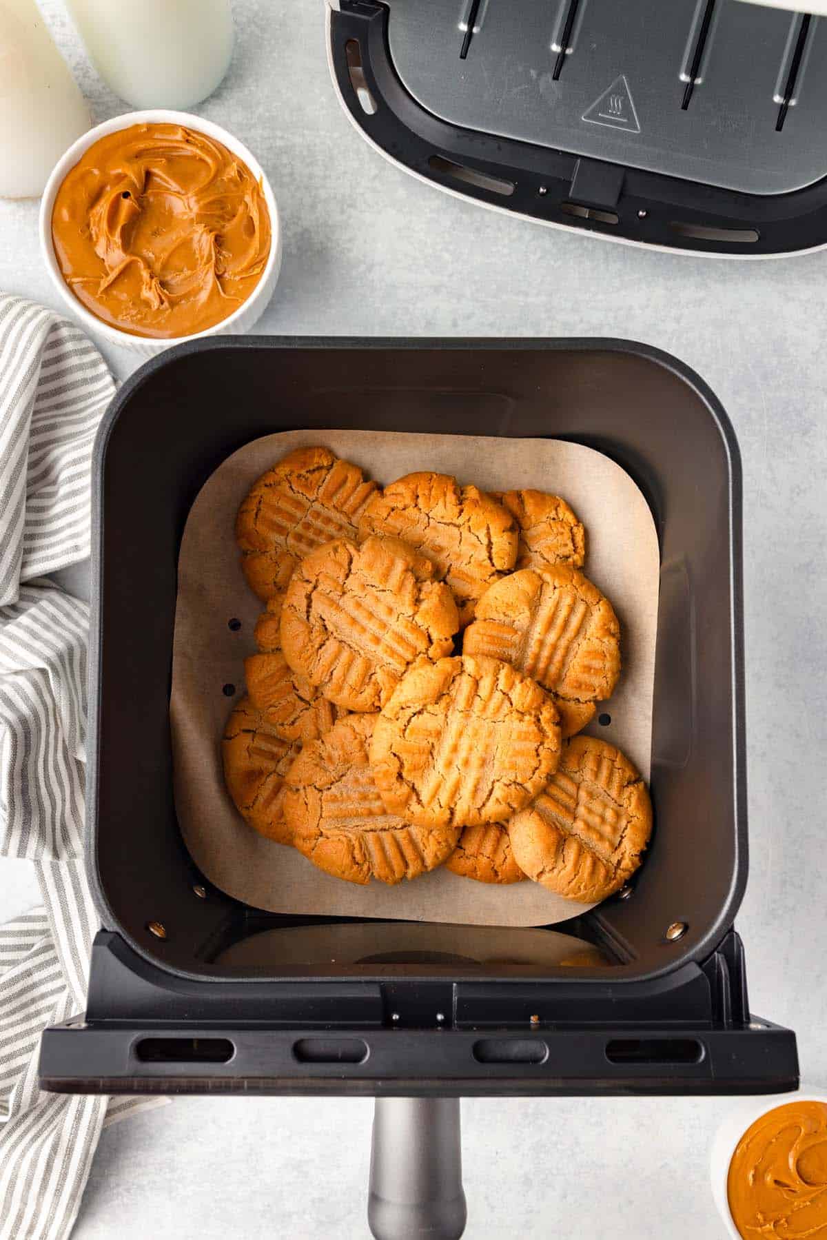 Some peanut butter cookies in an air fryer basket.