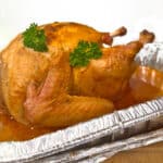 A smoked turkey sitting in an aluminum pan.