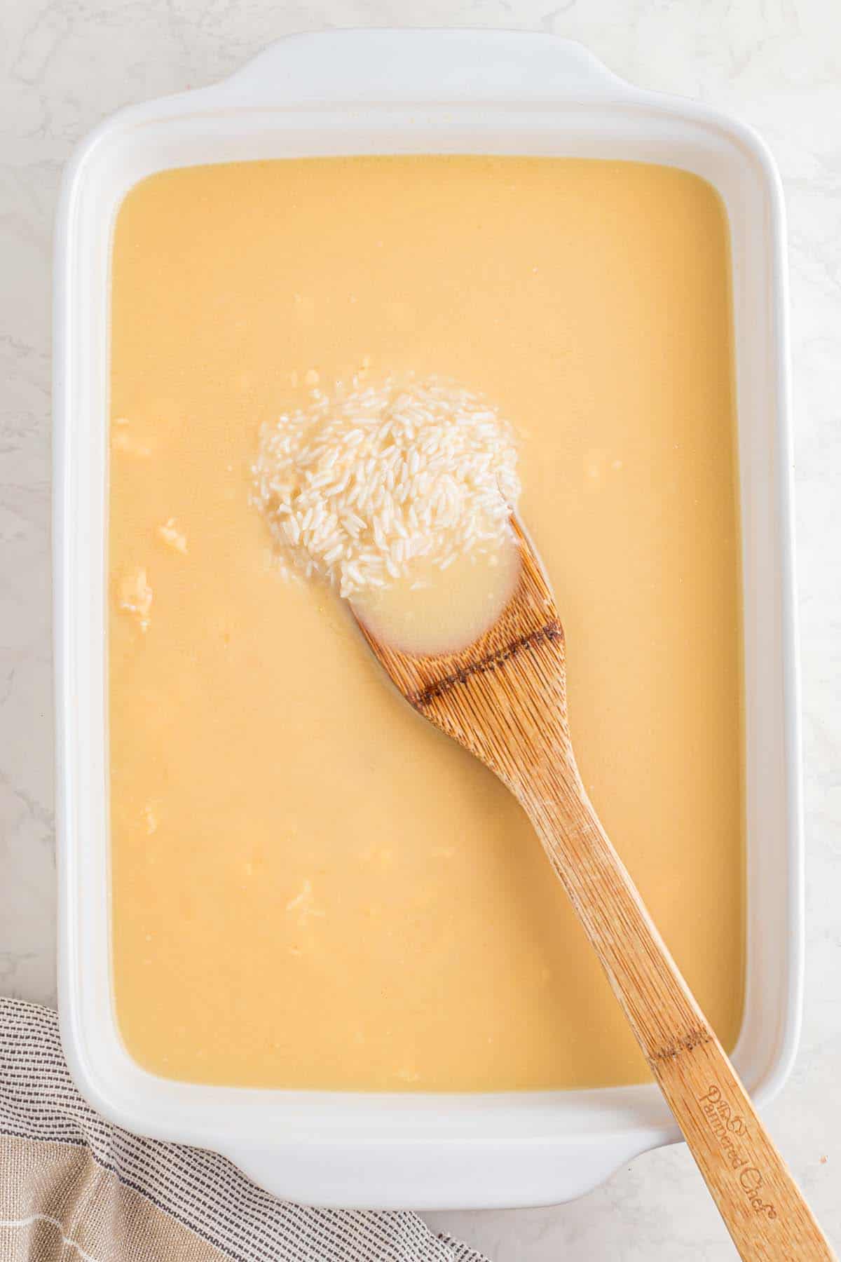 A casserole dish with some broth and rice in it.