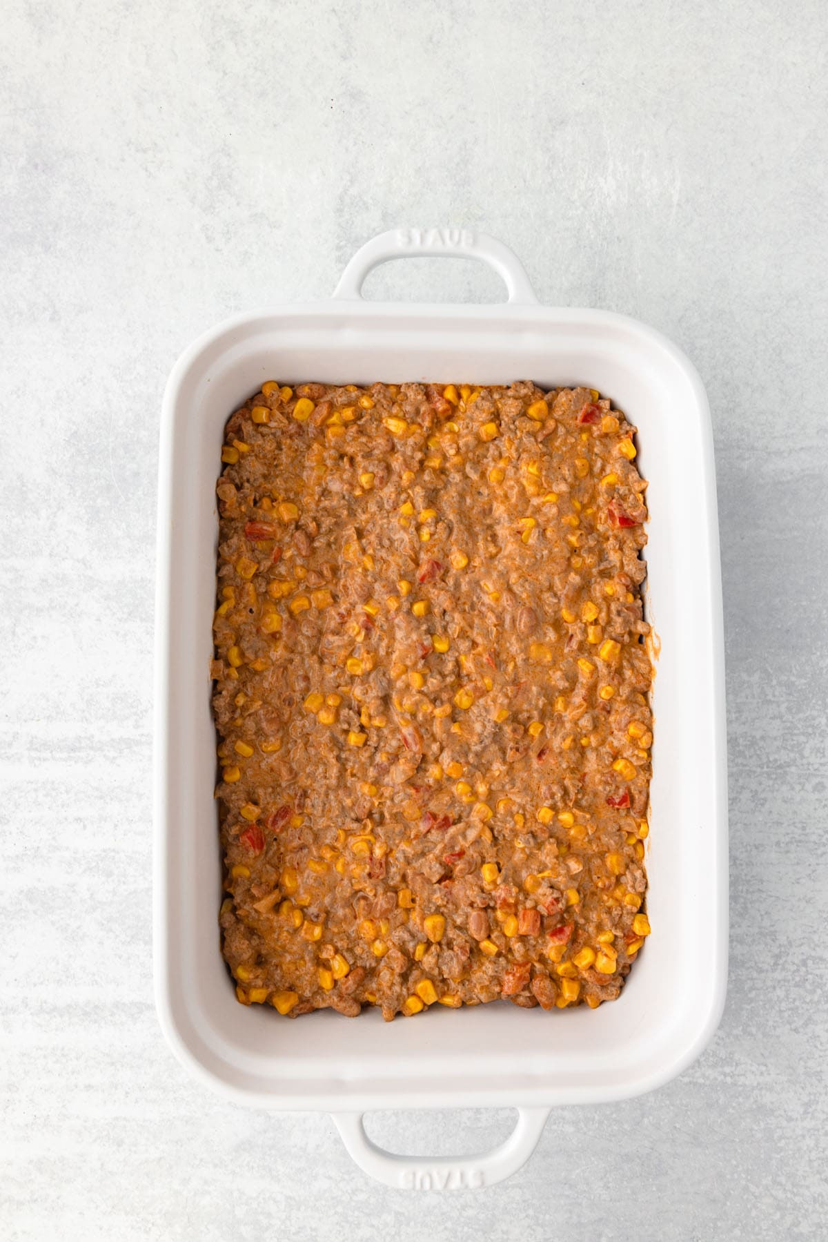 Some ingredients spread into a casserole pan.