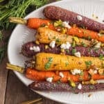 A plate of rainbow carrots with goat cheese sprinkles.