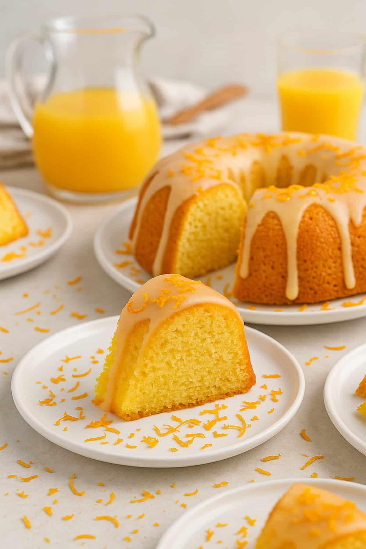 A bunt cake with some orange zest, on little plates.