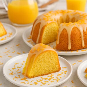 An orange bundt cake with slices cut out.