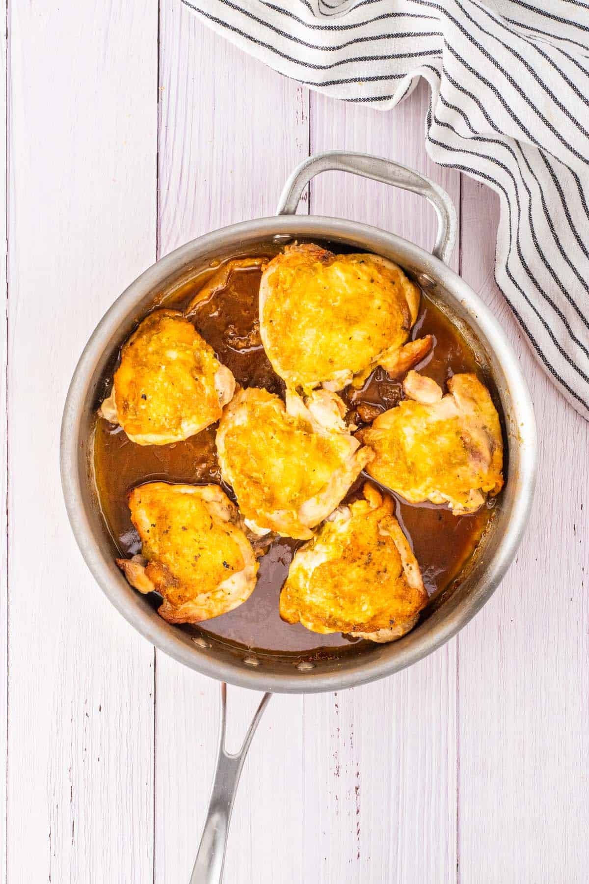 Some chicken thighs in a pan.
