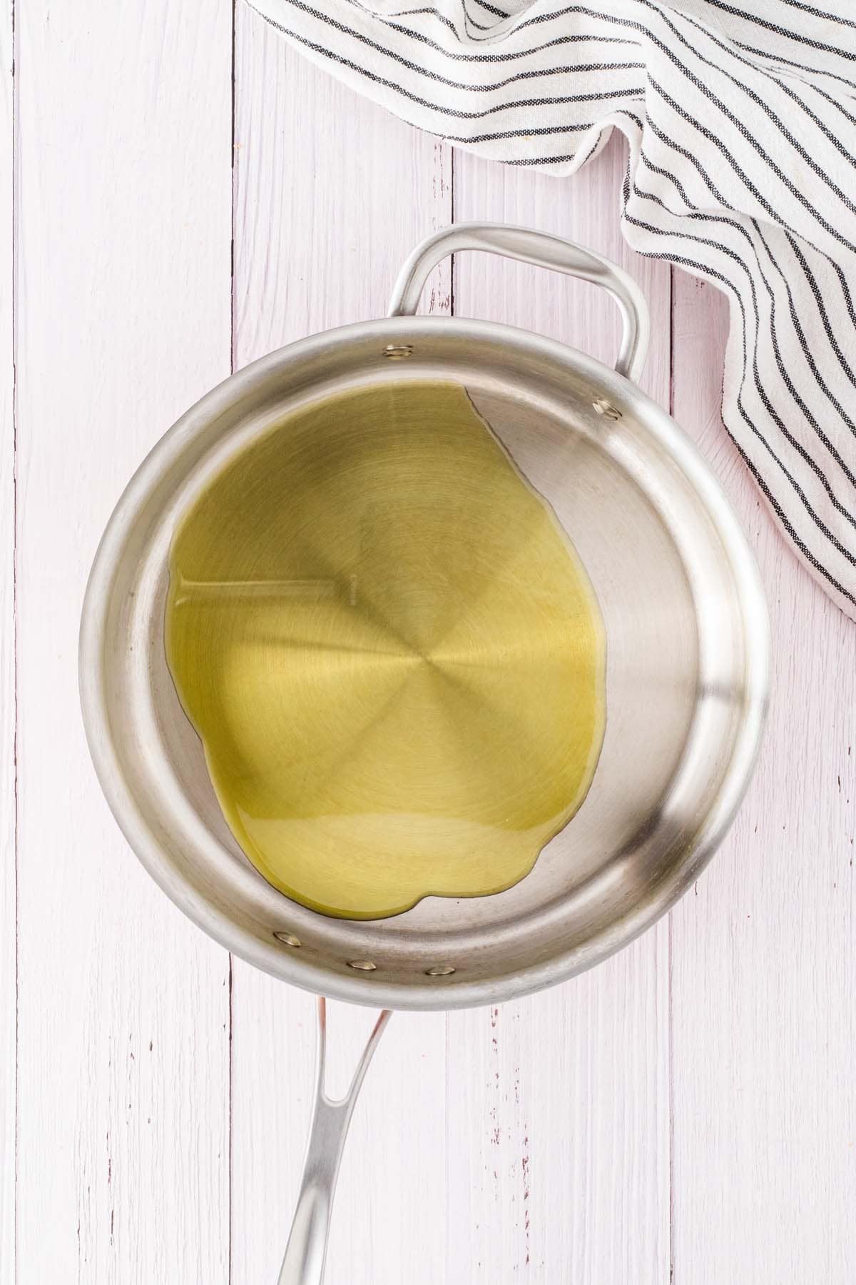 Heating some oil in a pan.