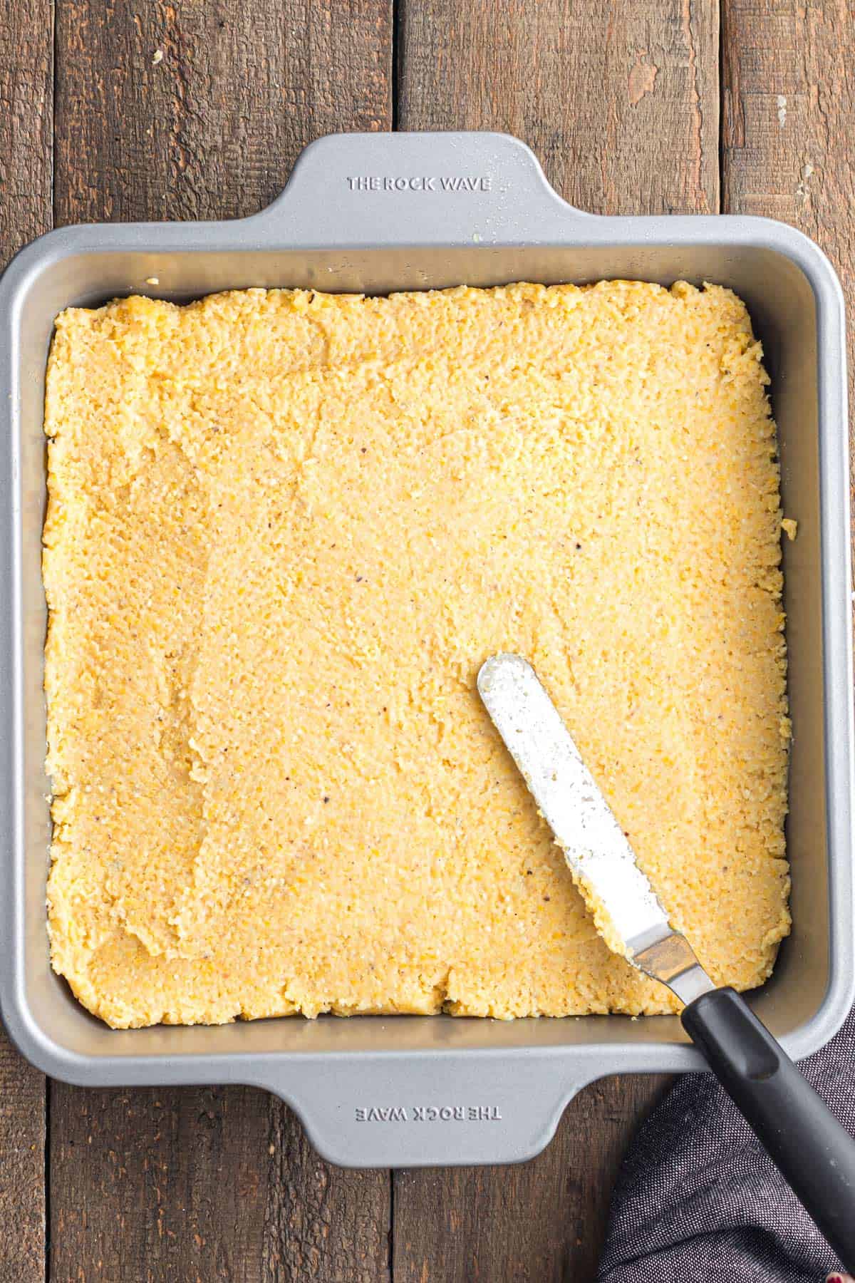 A pan of polenta and an offset spatula.