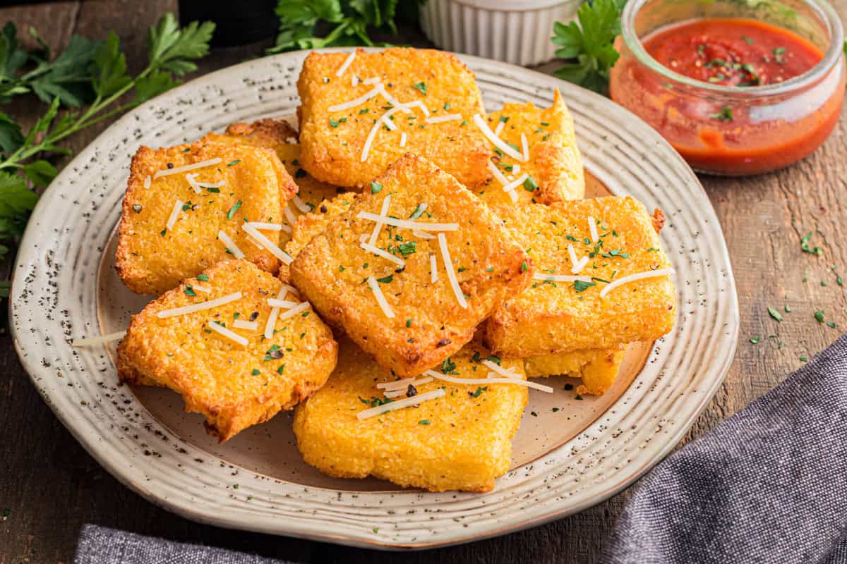 A plate of homemade air fryer polenta with marinara dipping sauce.