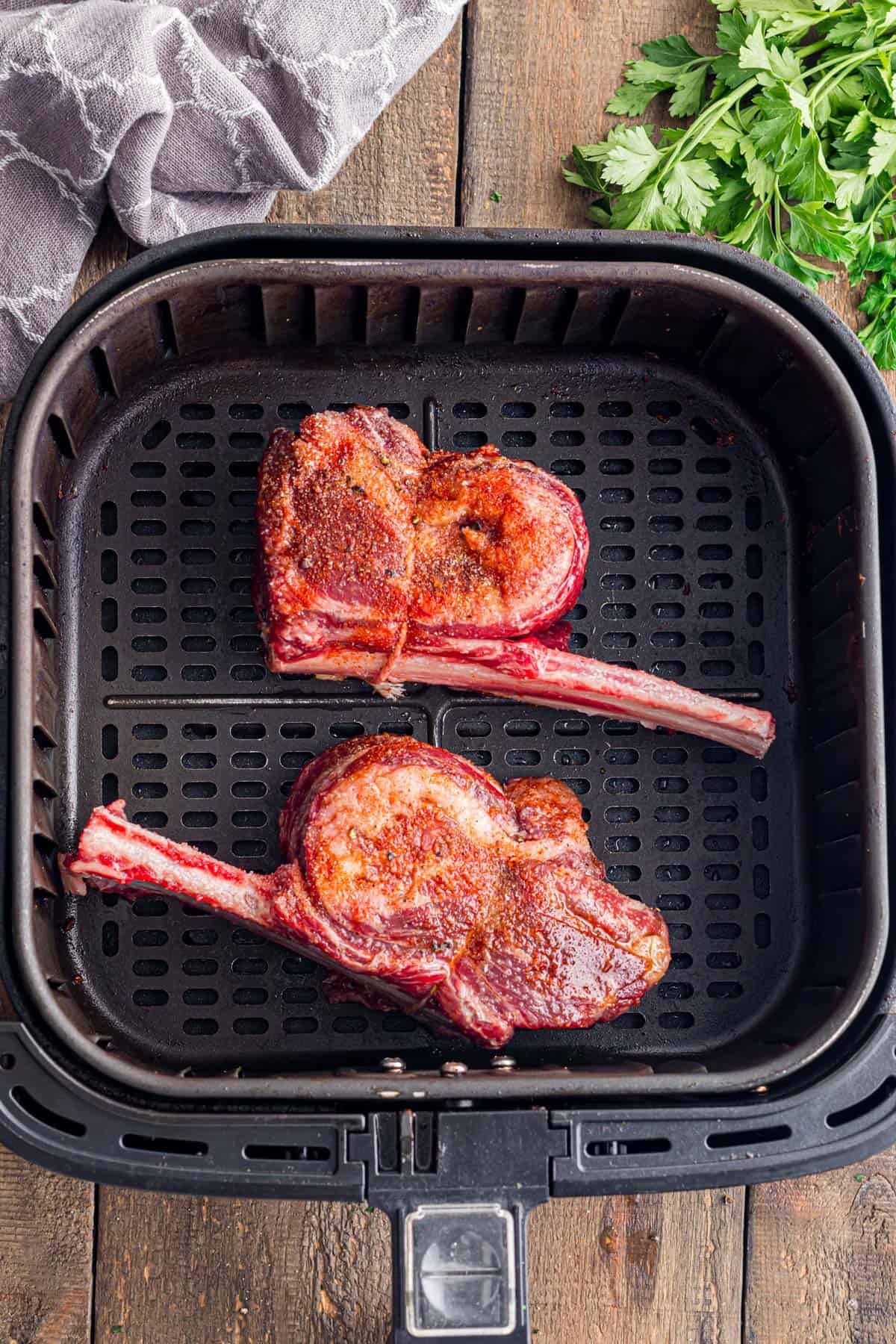 Two short ribs in an air fryer.