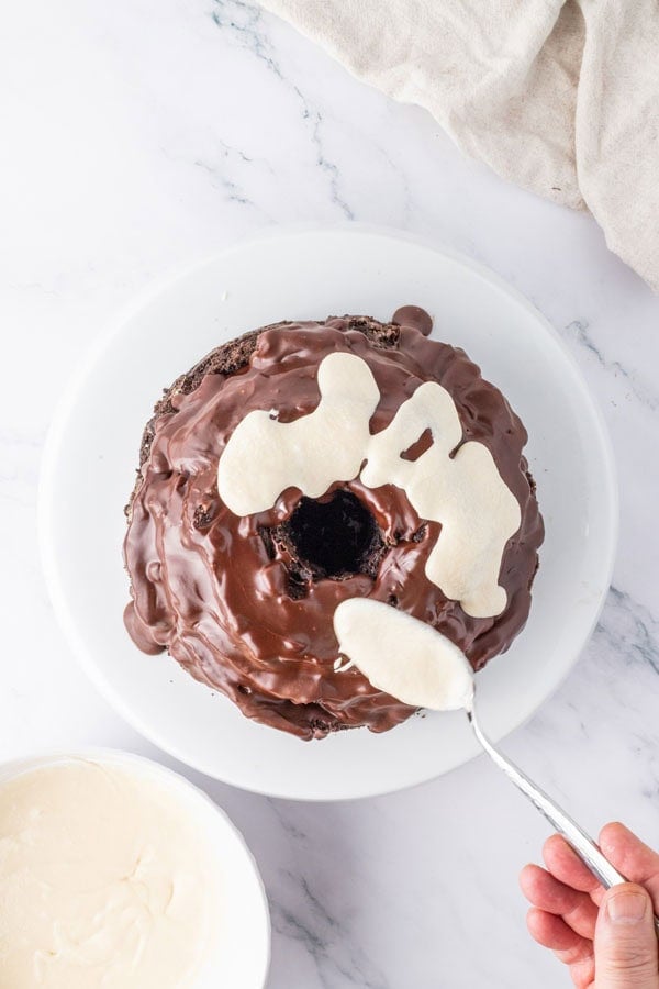 Drizzling a vanilla glaze over a chocolate Bundt cake.
