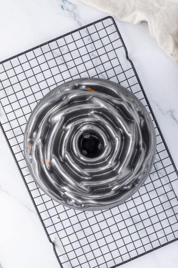 An inverted Bundt cake on a wire rack.