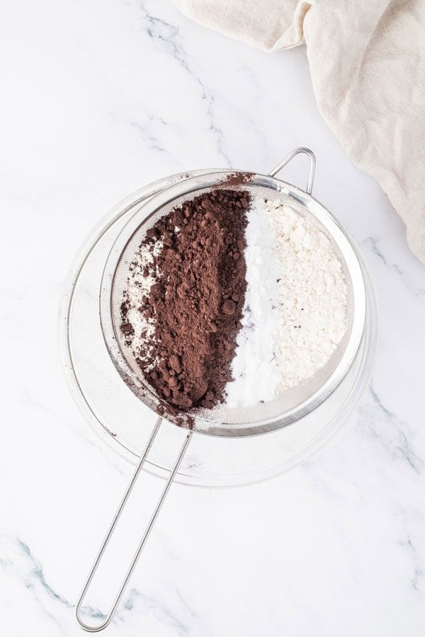 A sifter with black cocoa and flour.